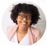 Smiling person with curly hair and glasses.