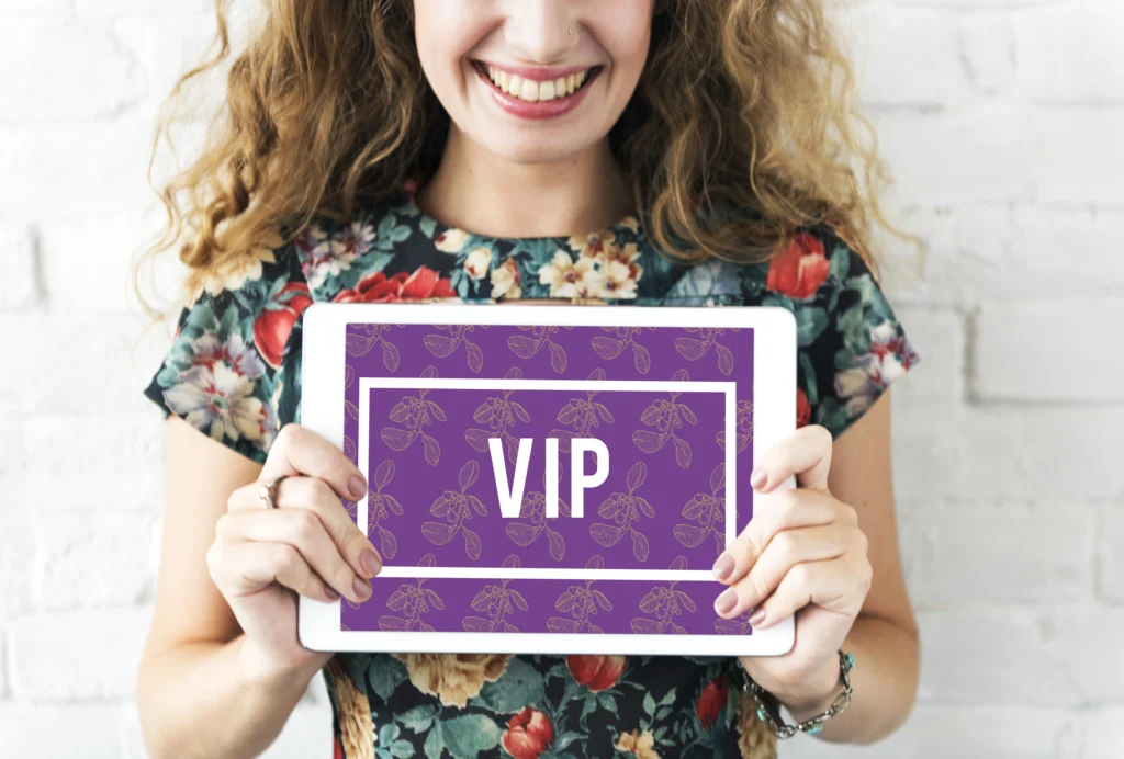 Smiling woman holding VIP sign on tablet.