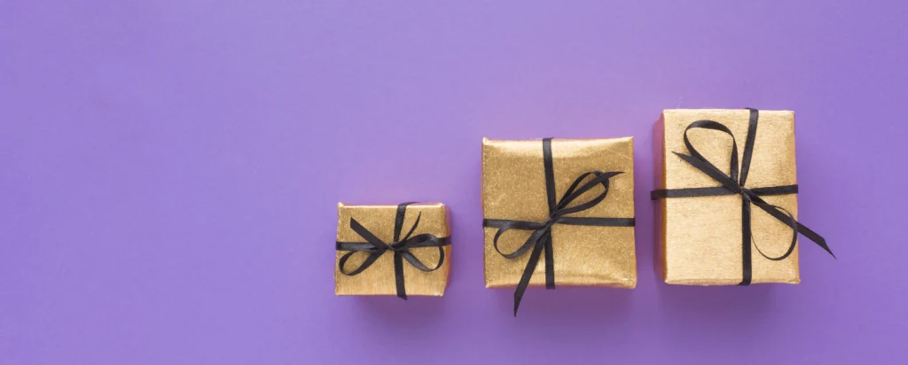Three gold gifts with black ribbons on purple